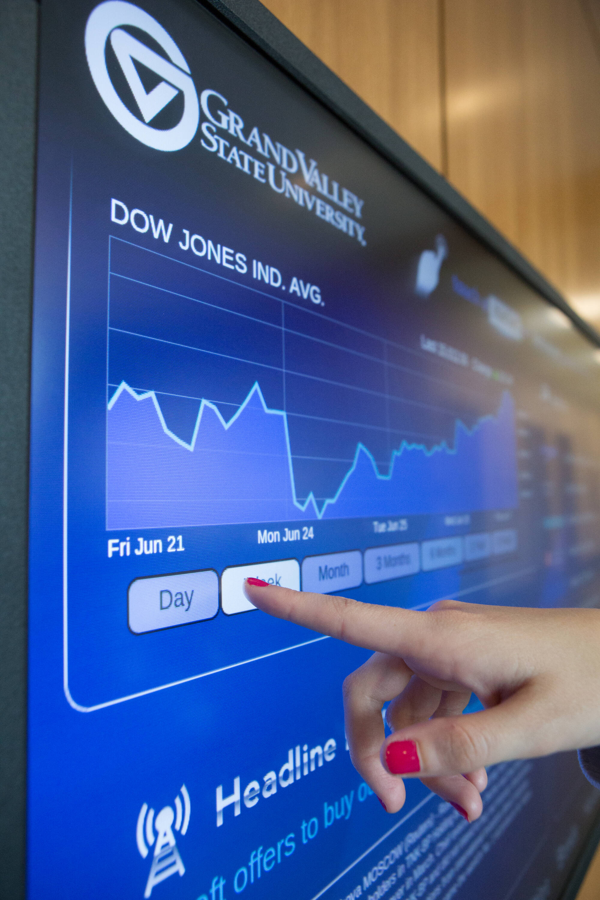 Person touching a computer screen with Stock information on it